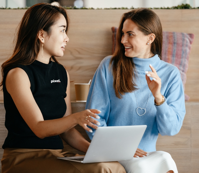 Multiracial businesswomen with laptop talking about work